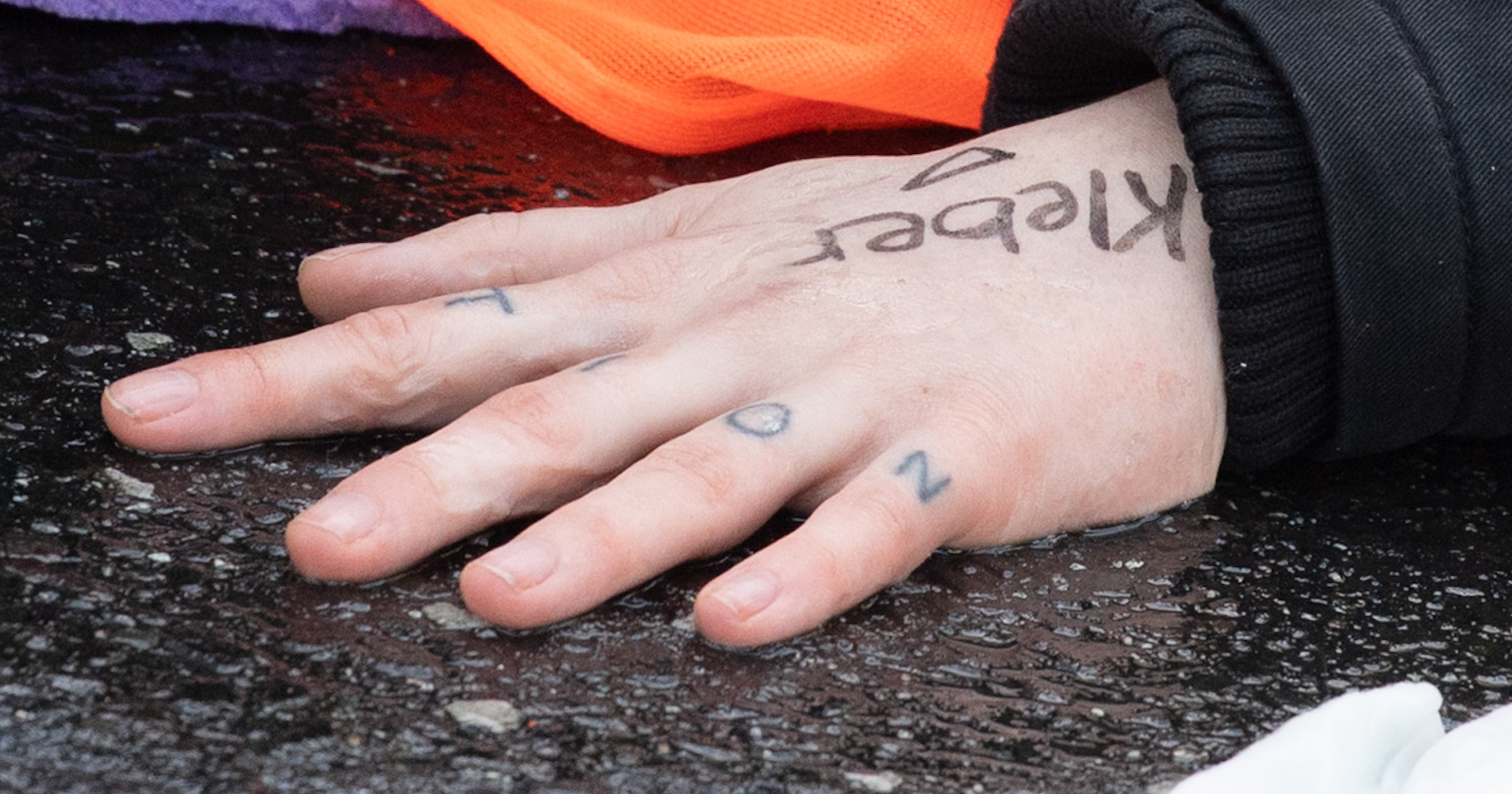 Eine Hand auf nassem Asphalt | Credit:  Boris Roessler / dpa / picturedesk.com