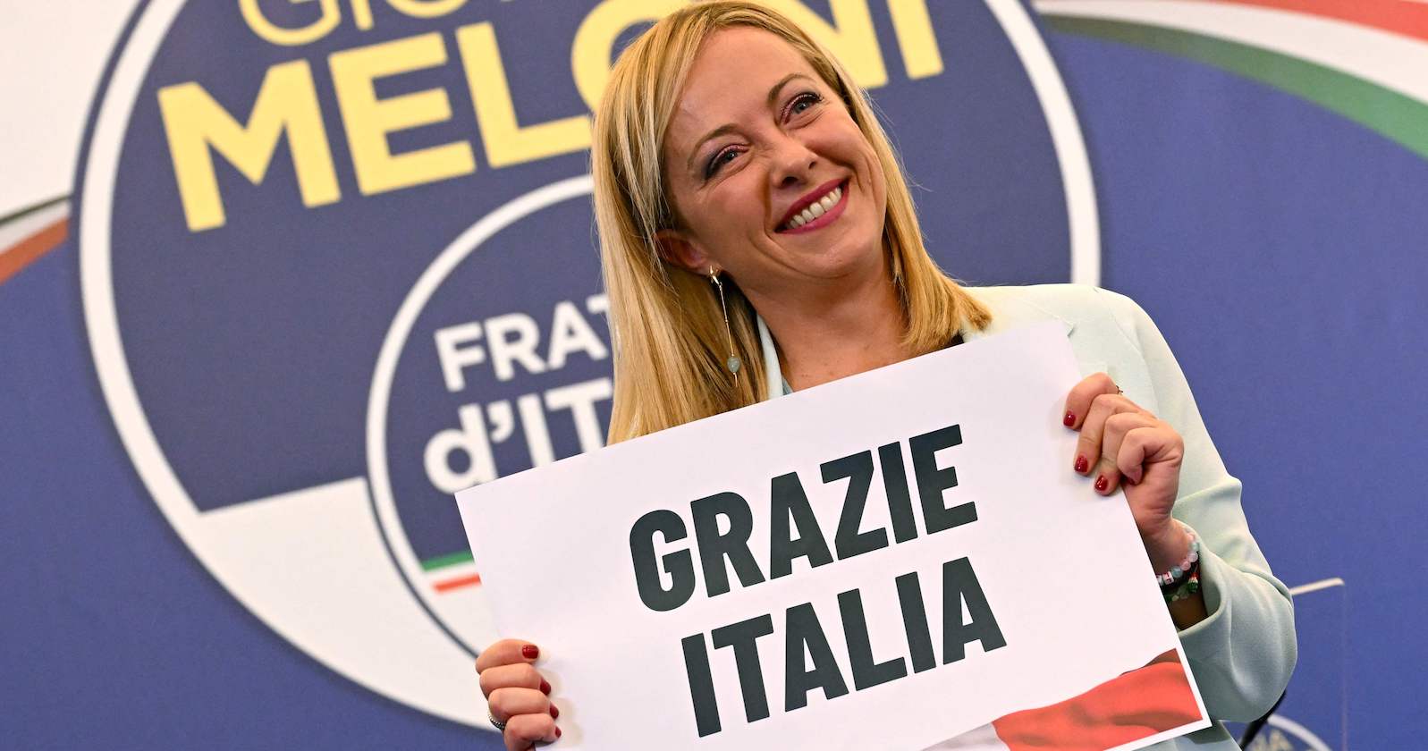 Parteichefin Meloni mit einem Schild &quot;Grazie Italia&quot;