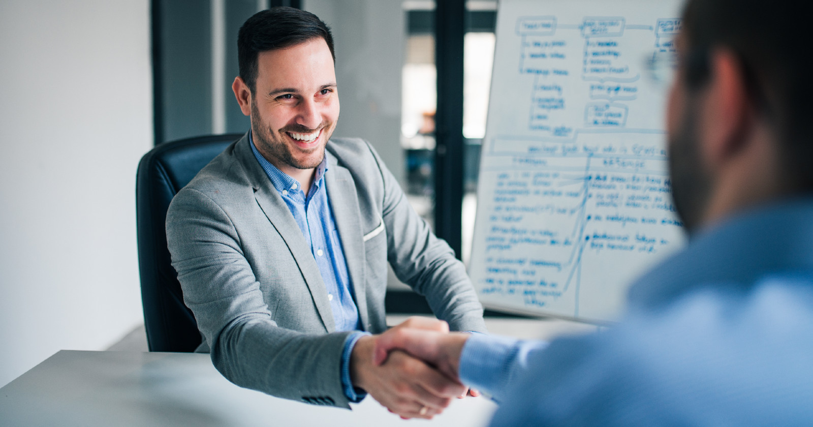 Chef schüttelt einem Mitarbeiter die Hand | Credit: iStock.com/nortonrsx