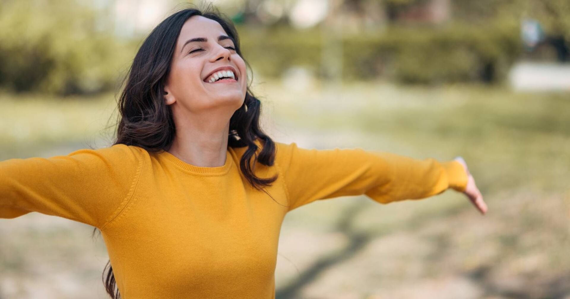 Junge Frau streckt entspannt ihre Arme weit von sich | Credit: iStock.com/nortonrsx