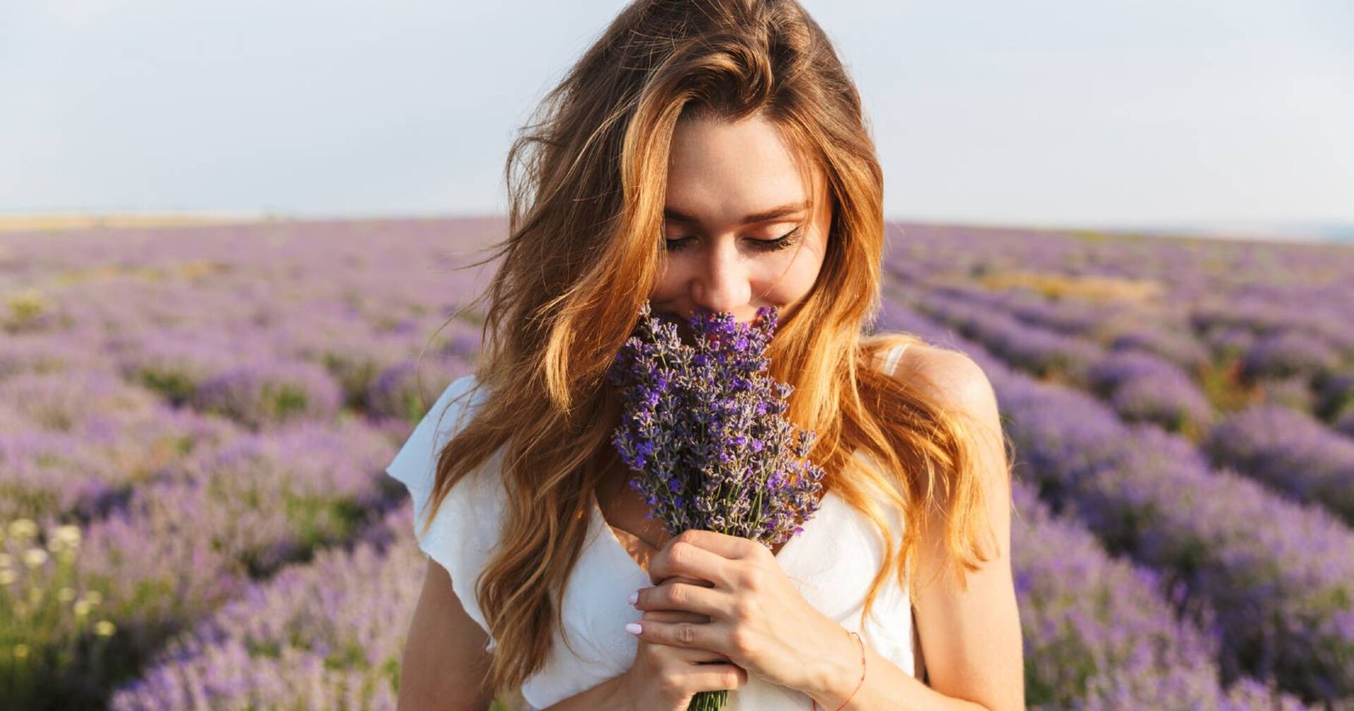Junge Frau mit einem Bund Lavendel in der Hand | Credit: iStock.com/DeanDrobot
