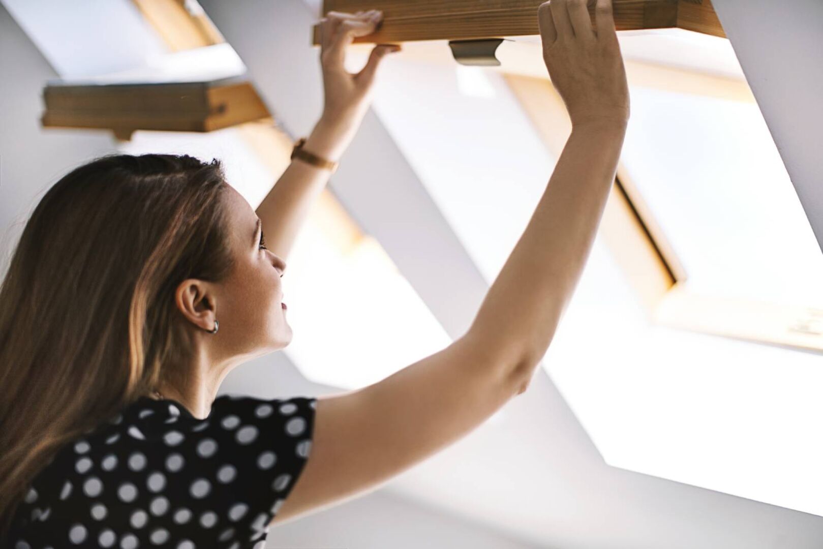 Frau beim Stoßlüften ihres Dachfensters | Credit: iStock.com/dragana991