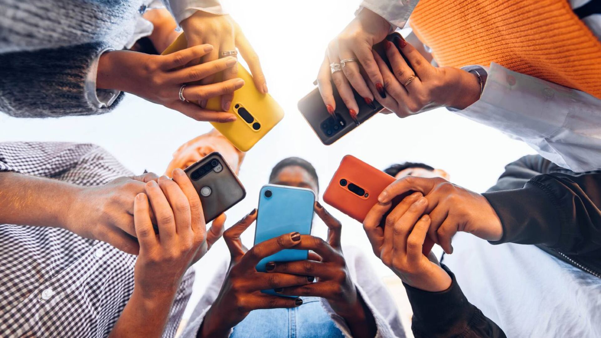 Männer und Frauen mit ihren Smartphones in der Hand | Credit: iStock.com/Kar-Tr