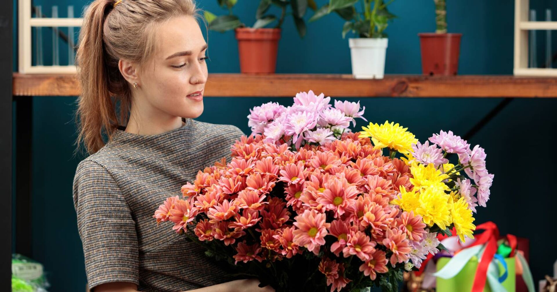 Junge Frau mit Chrysanthemen in der Hand | Credit: iStock.com/Svyatoslav Balan