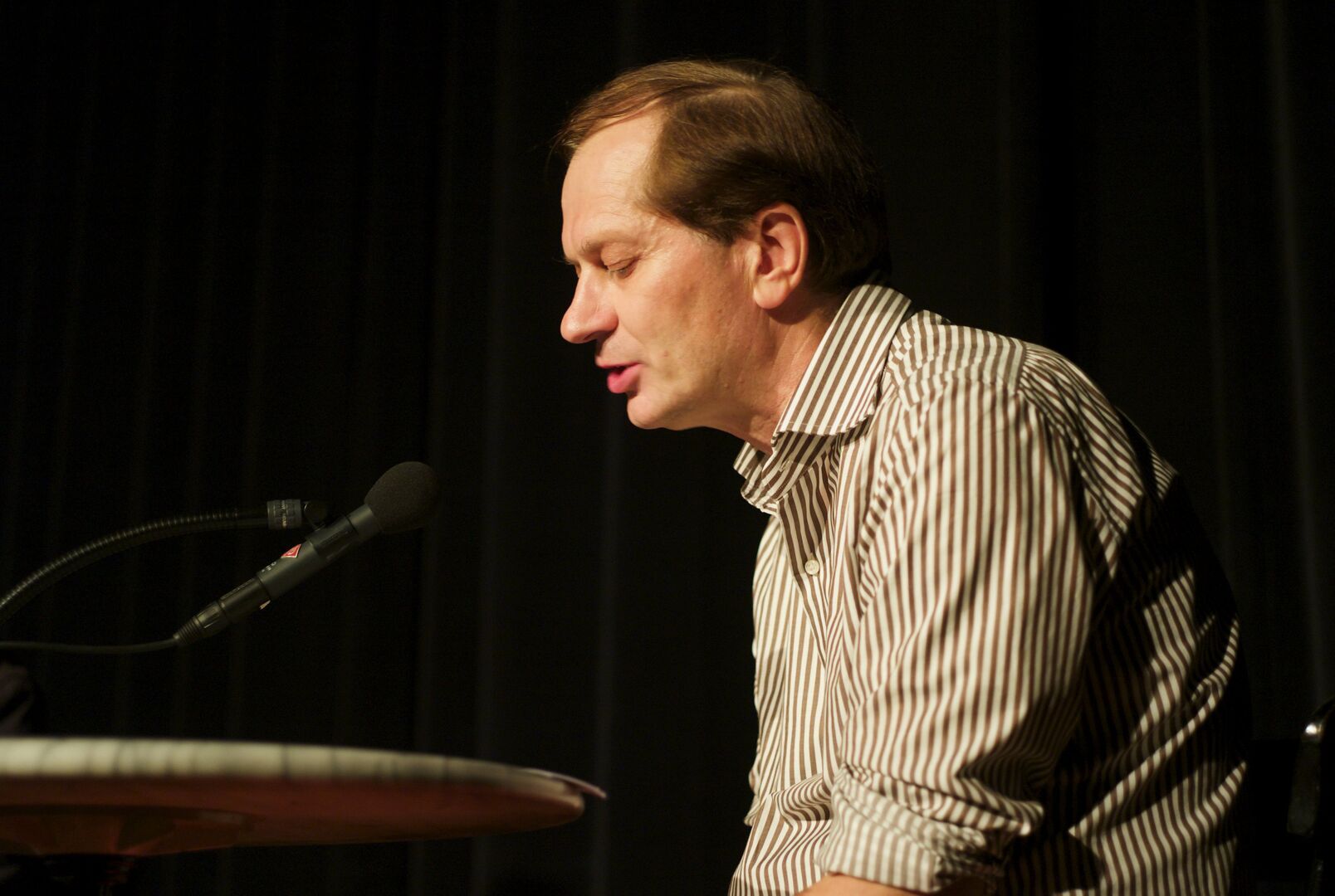 Josef Winkler vor dem Rednerpult im Seitenprofil