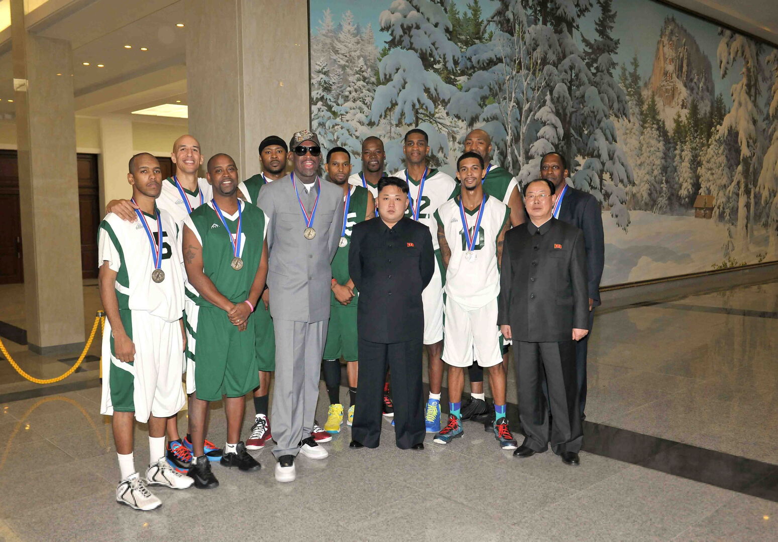 Dennis Rodman und Kim Jong-un, die inmitten der nordkoreanischen Basketballmanschaft stehen.