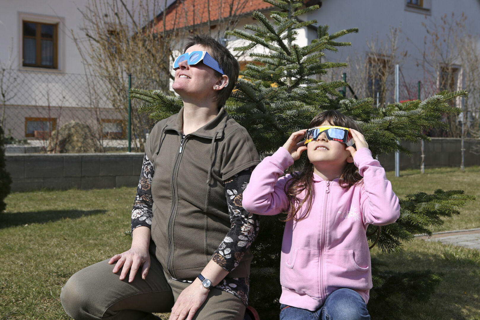 Frau und Mädchen beobachten Sonnenfinsternis mit Schutzbrillen. | Credit: Ernst Weingartner / Weingartner-Foto / picturedesk.com