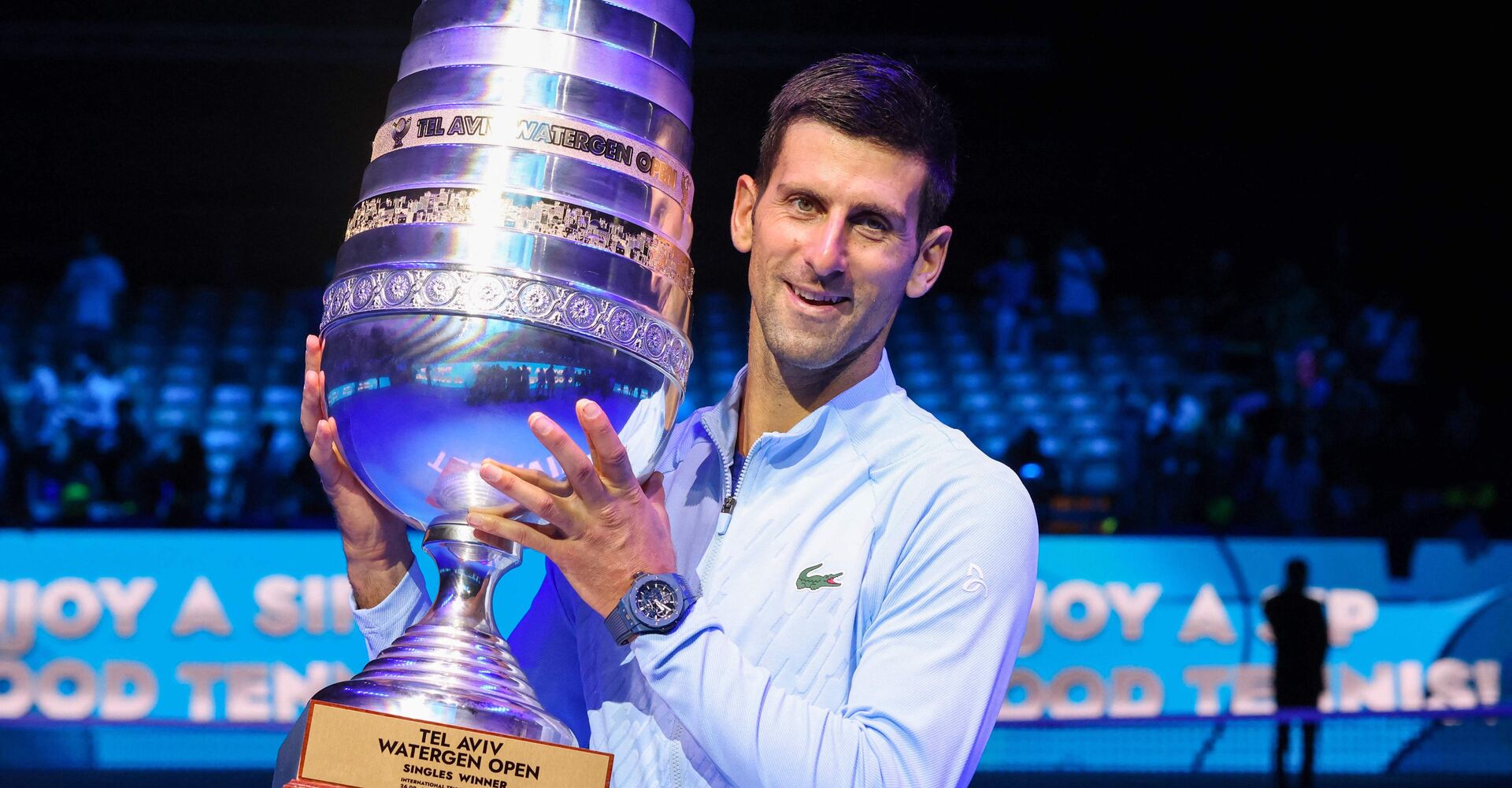 Tennis-Spieler Novak Djokovic mit dem außerordentlich großen Pokal von Tel-Aviv