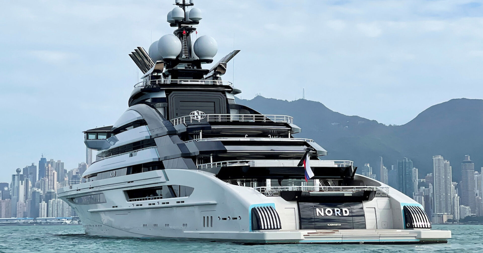 Jacht von schräg vorne im Meer, dahinter Skyline