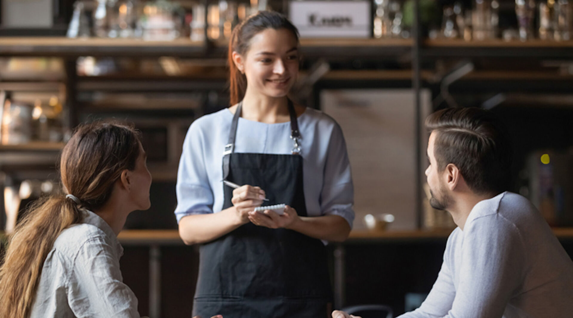 Kellnerin bedient junges Pärchen | Credit:Istock.com/fizkes