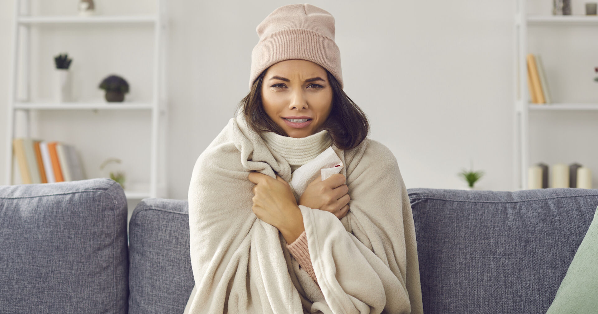 Frierende Frau auf der Couch | Credit: iStock.com/Lacheev