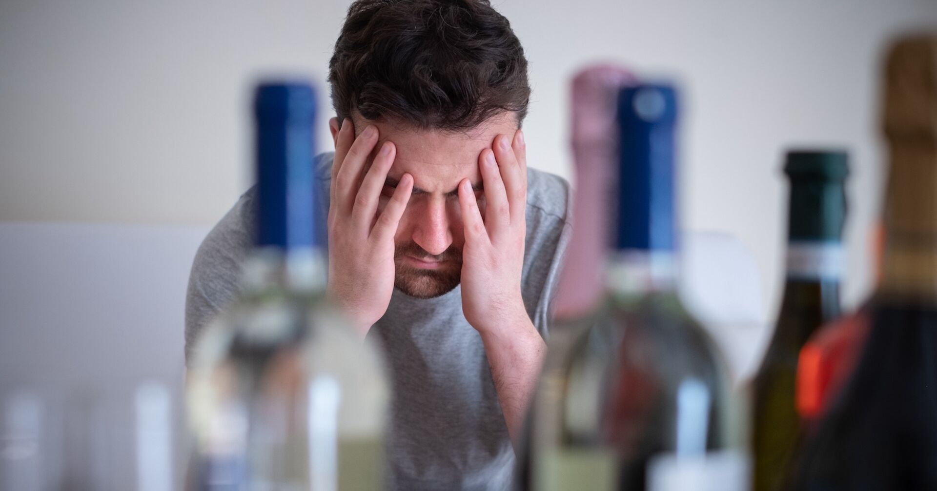 Mann hat Kopfschmerzen nach zu viel Alkohol. Credit: iStock.com/tommaso79