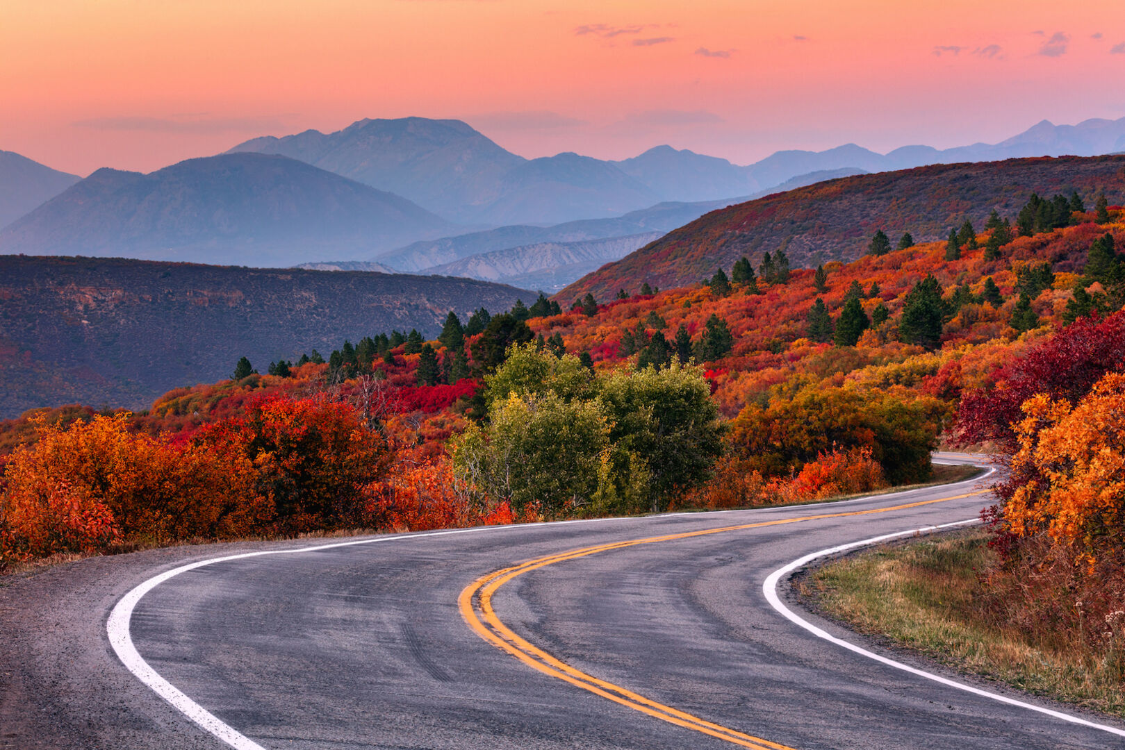 Wald und Straße im Herbst in den USA. | Credit: iStock.com/mdesigner125