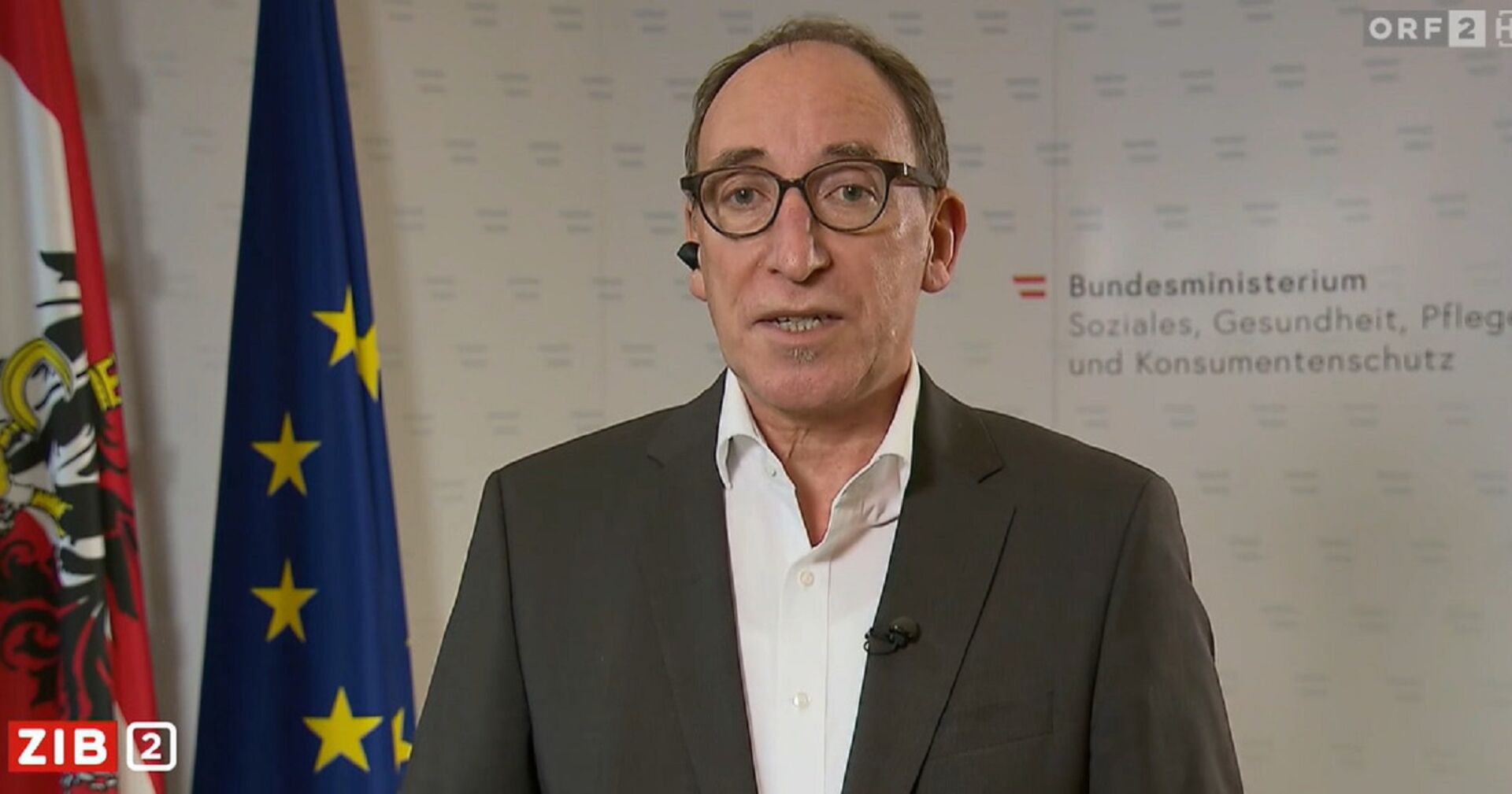 Johannes Rauch in einer Zuschaltung vor der Pressewand des Ministerums.
