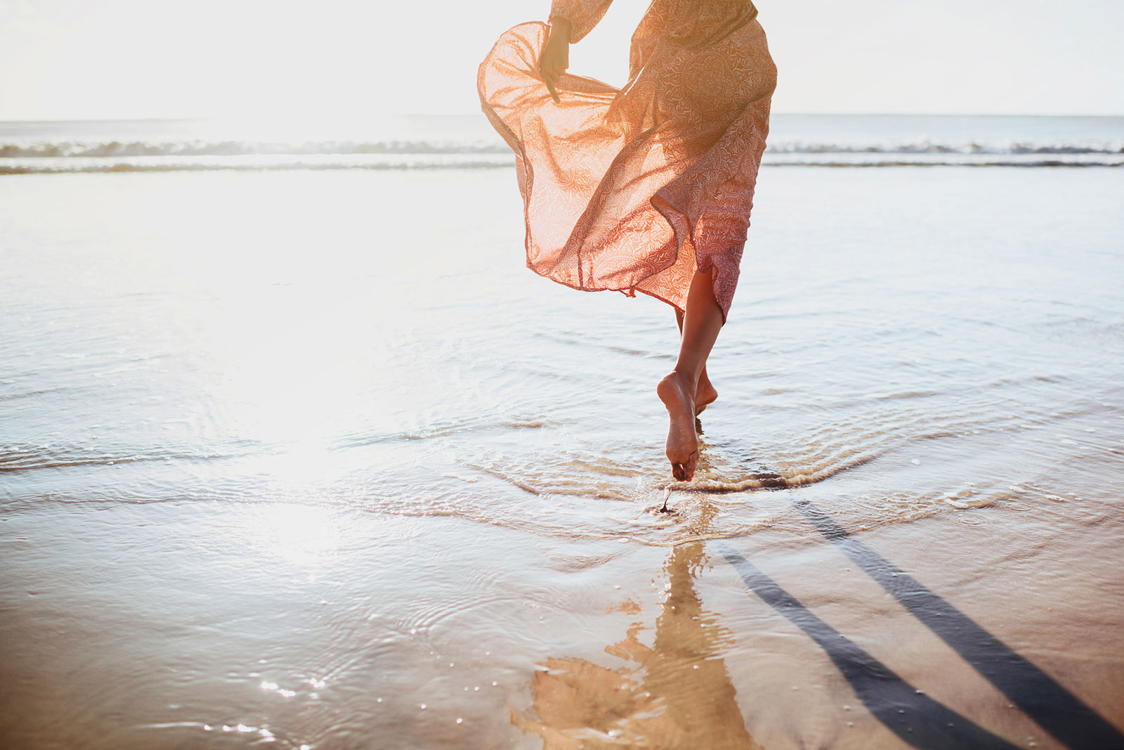 Frau läuft den Strand entlang | Credit: iStock.com/Margaryta Basarab