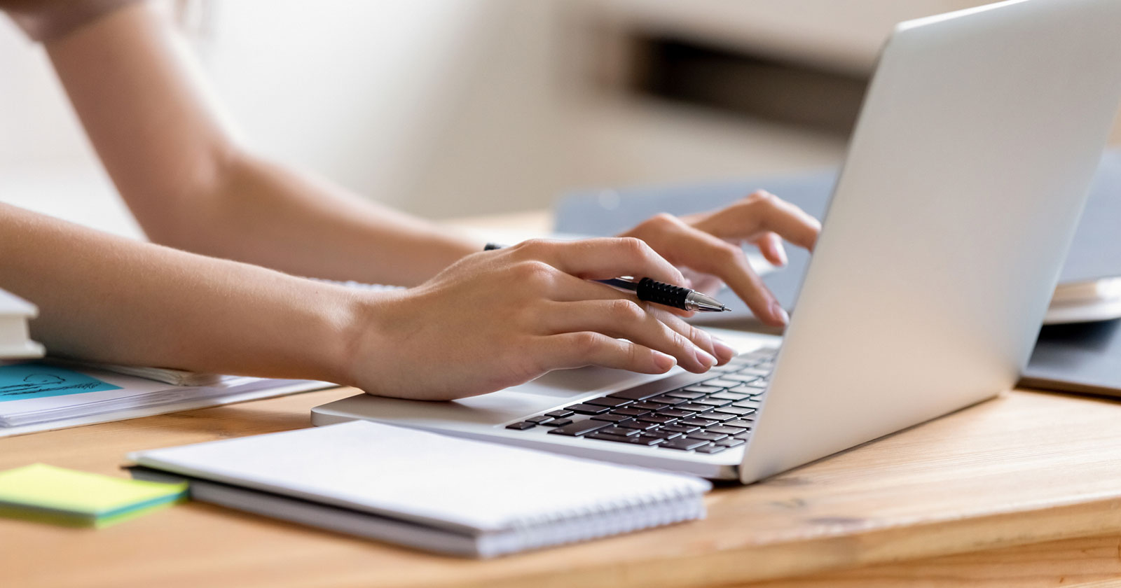 Junge Frau tippt auf ihrem Notebook | Credit: iStock.com/fizkes
