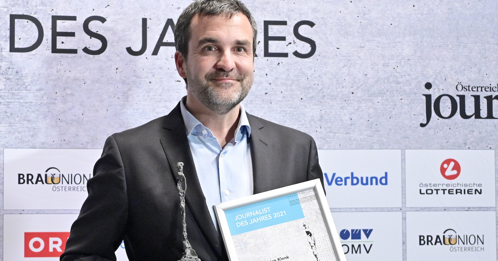 Porträt mit gerahmter Auszeichnung in den Händen