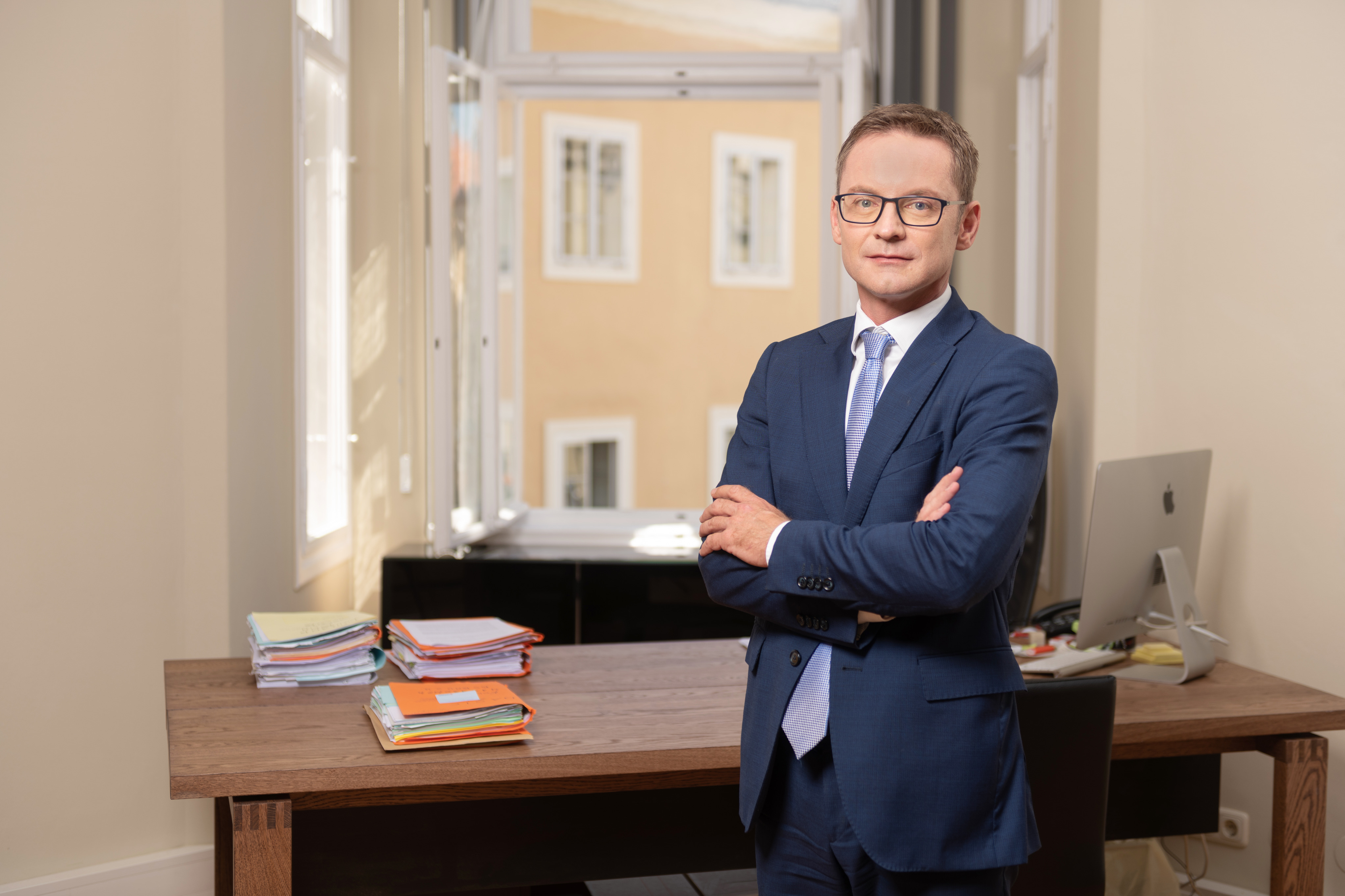 Rechtsanwalt Philipp Tschernitz, der bei offenem Fenster vor seinem Schreibtisch steht