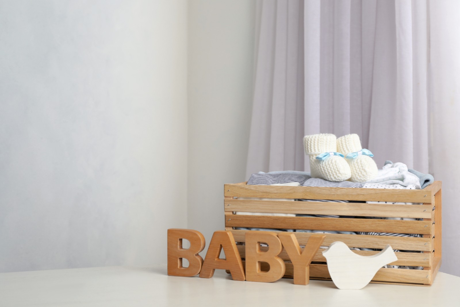 Das Wort &quot;Baby&quot; in Holzbuchstaben steht vor einer Holzkiste | Credit: iStock.com/Liudmila Chernetska