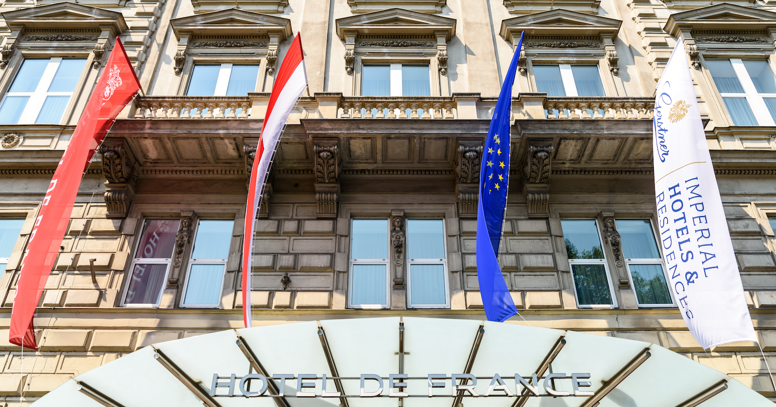 Fahnen über dem Eingang vom Hotel de France | Credit: iStock.com/radub85