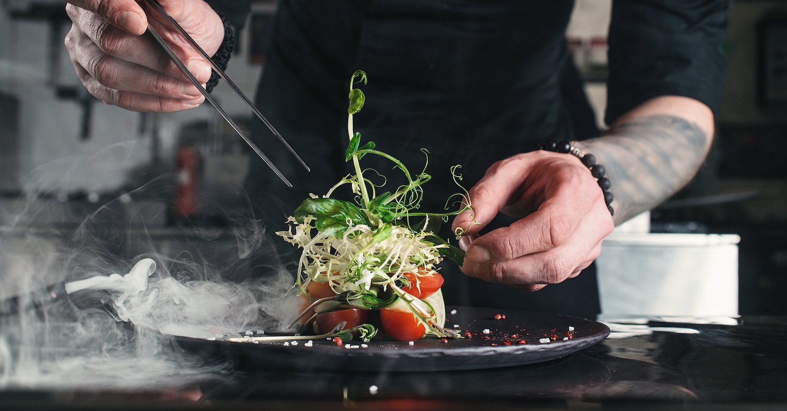 Koch richtet Salat an. | Credit: iStock.com/MykolaSenyuk