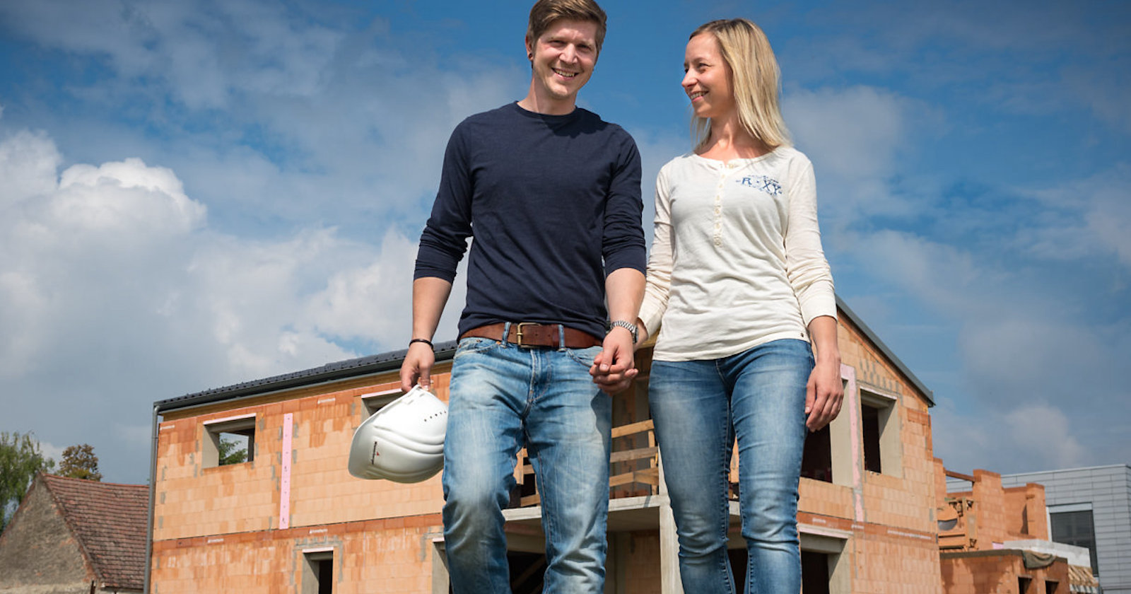 Junges Paar steht vor einem Ziegelrohbau| Credit: Andreas Hafenscher