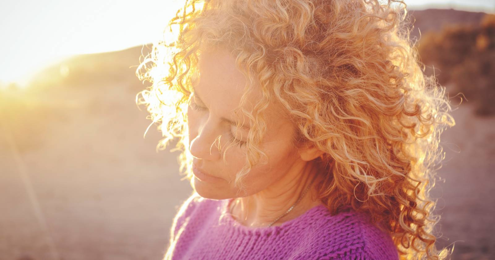 Junge Frau genießt mit geschlossenen Augen das Sonnenlicht | Credit: iStock.com/simonapilolla