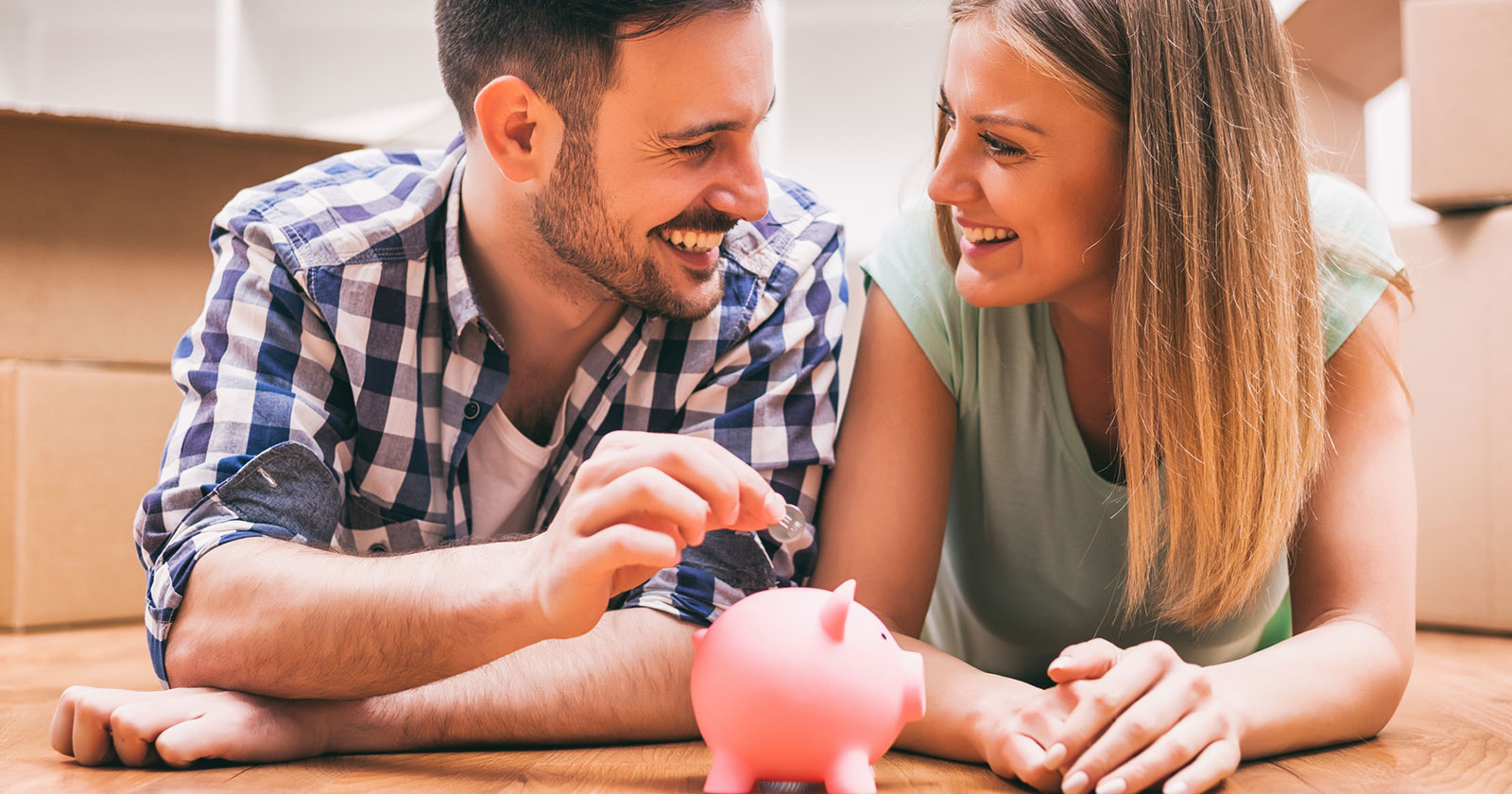 Glückliches Paar mit gemeinsamen Sparschweinchen | Credit: iStock.com/Photodjo