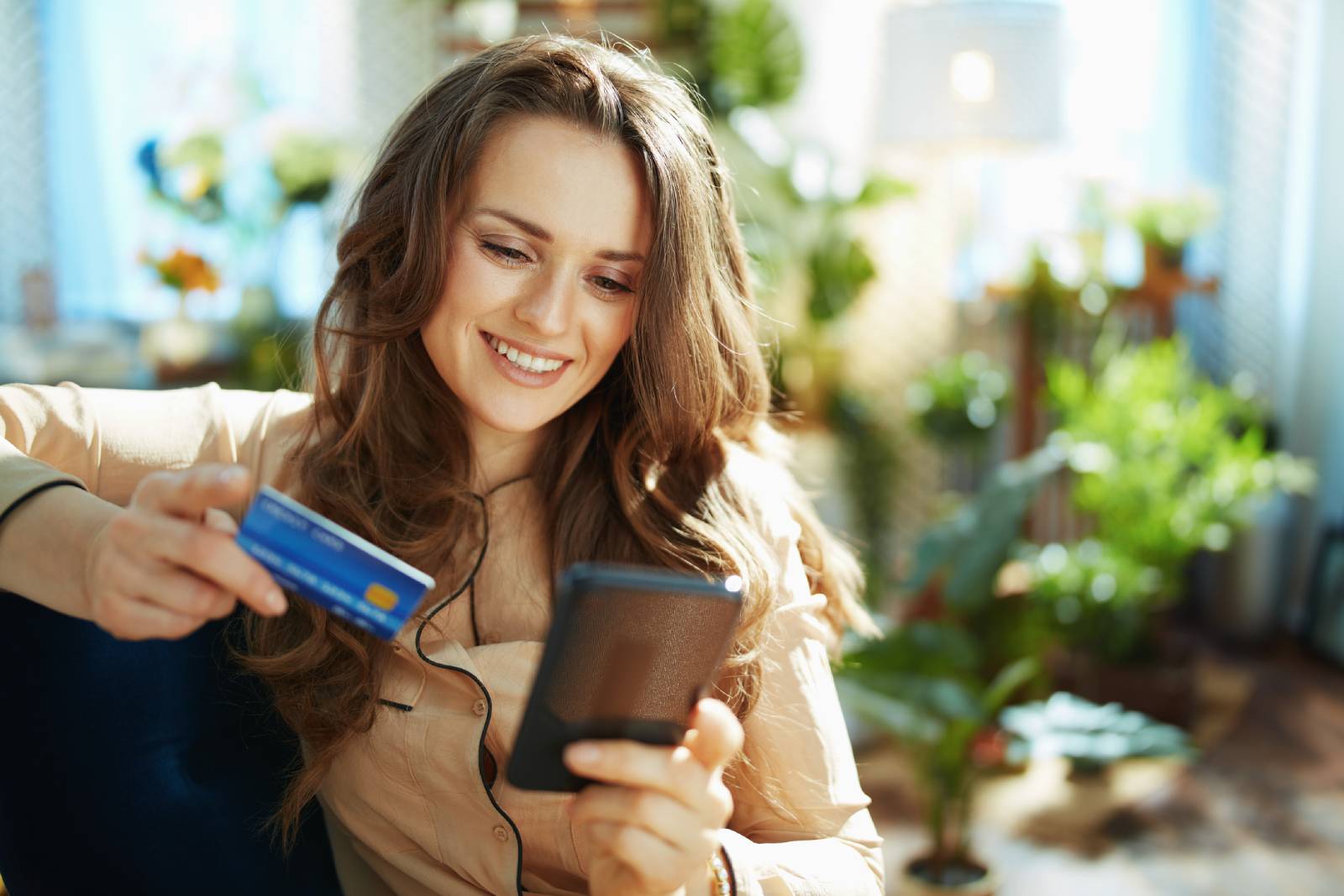Junge Frau beim Online Shopping via Smartphone | Credit: iStock.com/CentralITAlliance