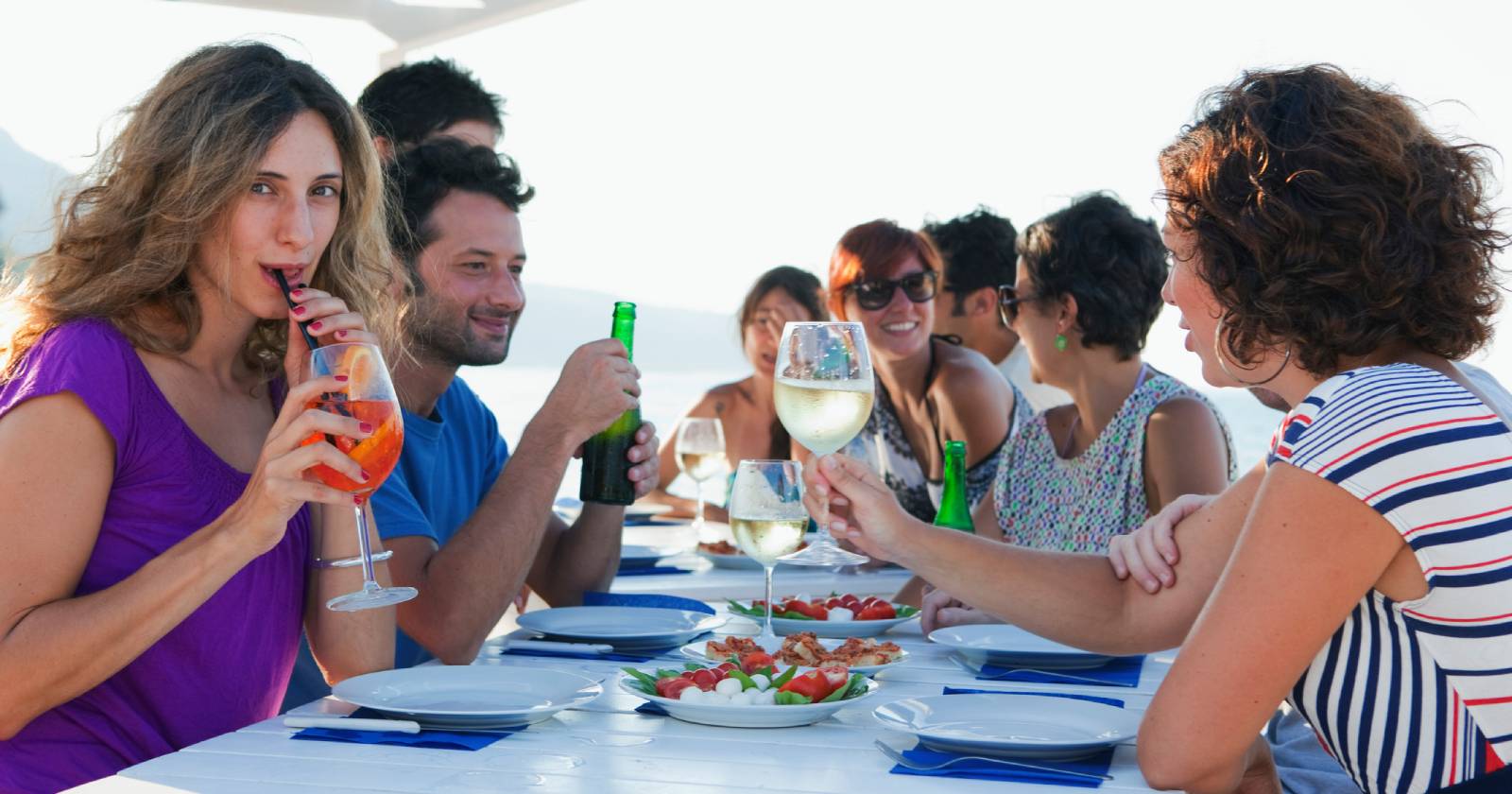 Gesellige Runde bei einem gemeinsamen Essen unter freiem Himmel auf Sizilien | Credit: iStock.com/Judith Haeusler