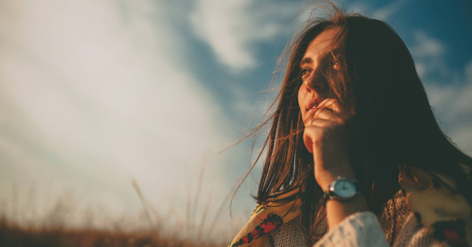 Junge Frau blickt nachdenklich in die Landschaft | Credit: iStock.com/max-kegfire