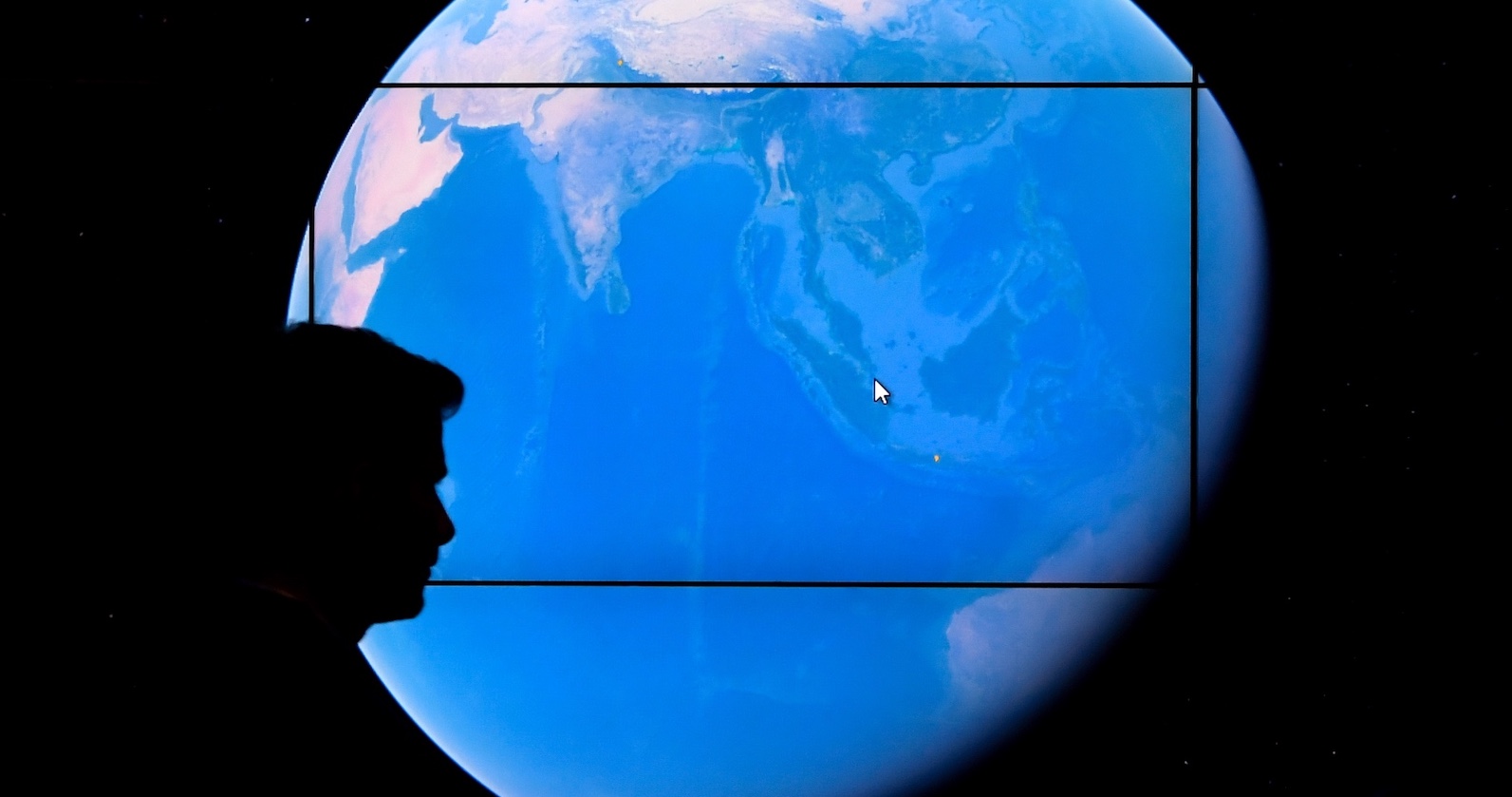 Schatten eines Menschen vor der Weltkugel. | Credit: TIMOTHY A. CLARY / AFP / picturedesk.com