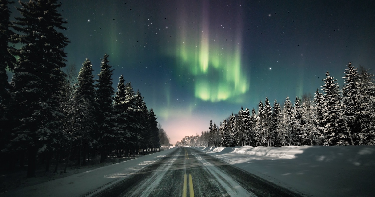Polarlichter und winterliche Straße in Norwegen. | Credit: Adobe Stock