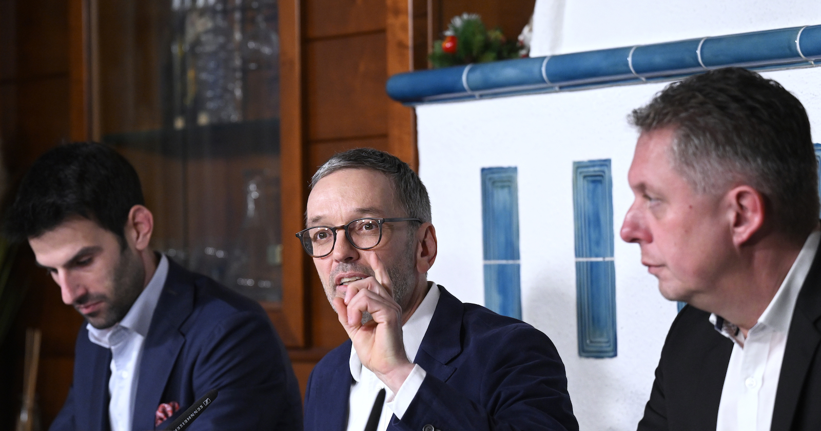 vor einem Kachelofen sitzend