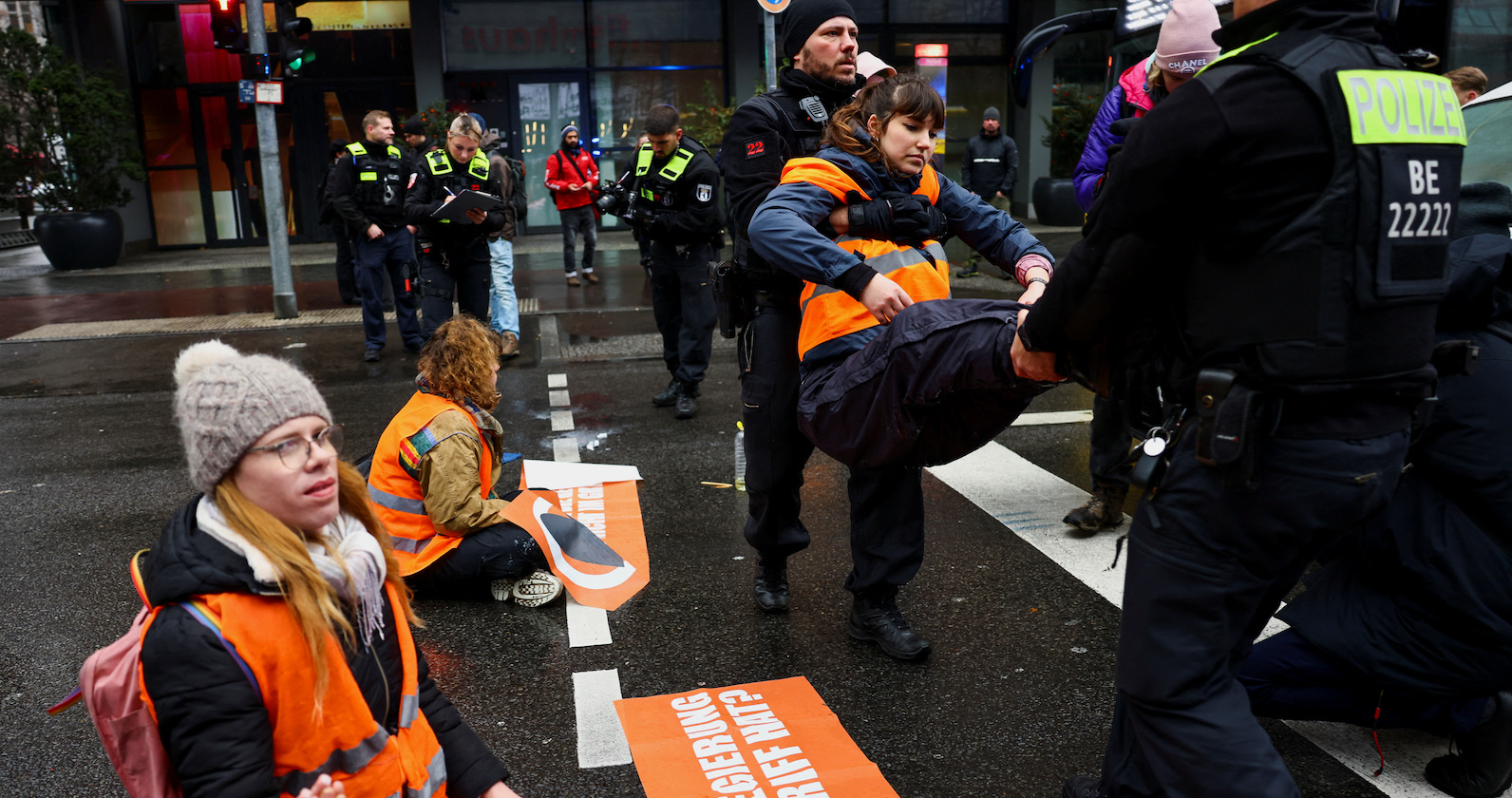 Demonstrantin wird von Polizisten weggetragen