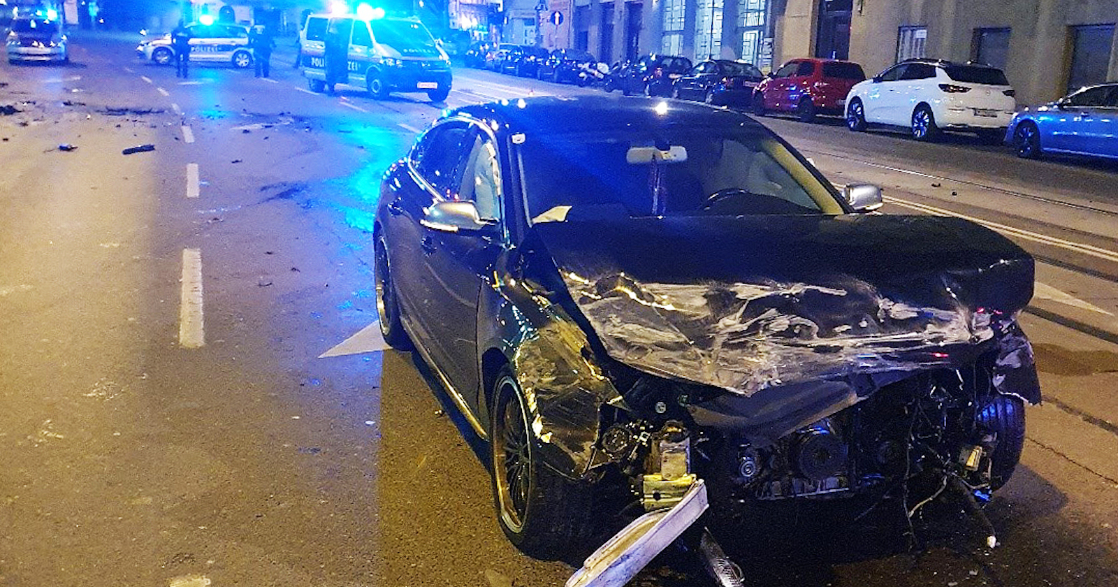 Autowrack, im Hintergrund Blaulicht