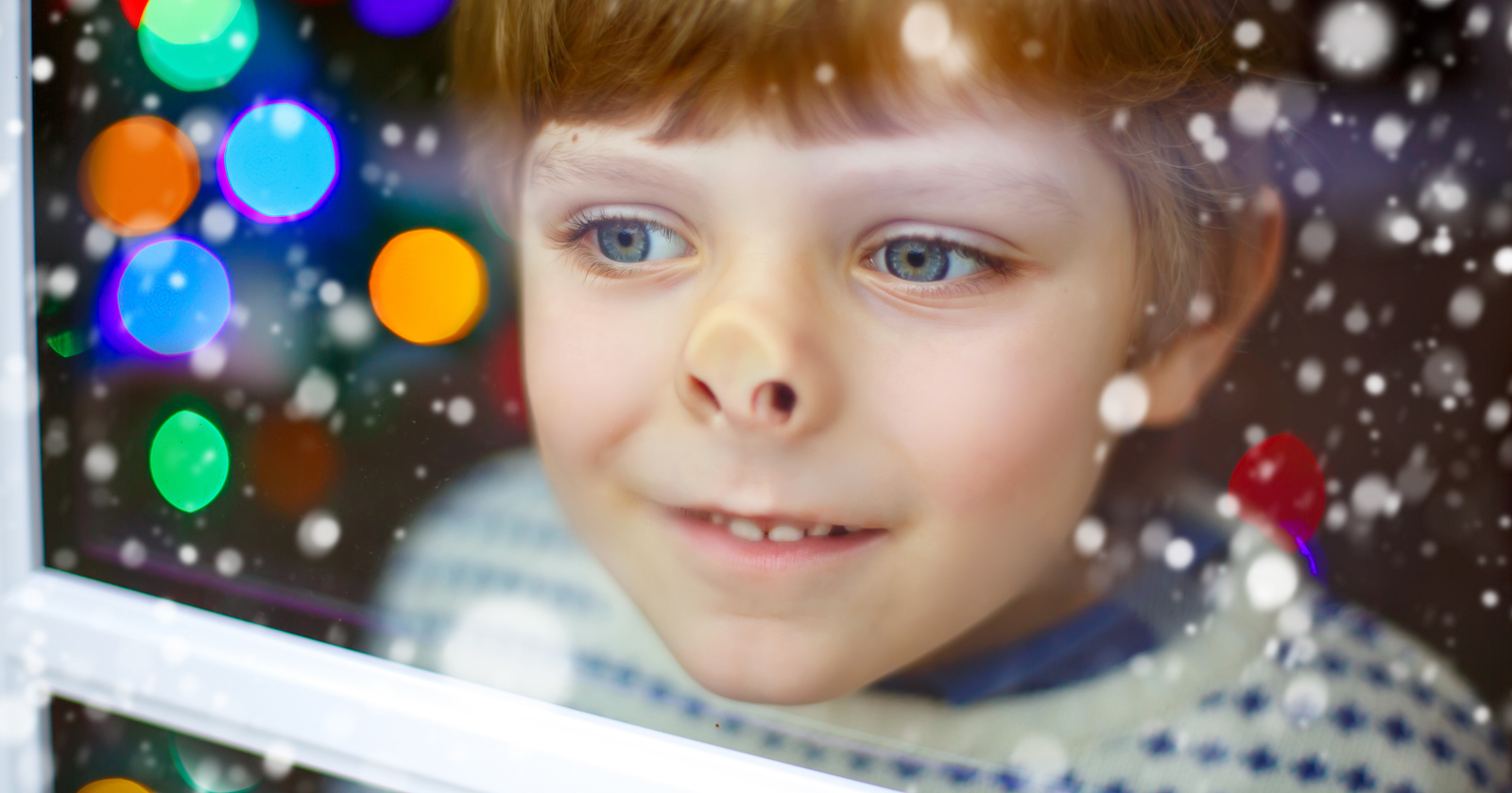 ein kleiner Junge im Pullover drückt die Nase ans Fenster | Credit: iStock.com/romrodinka