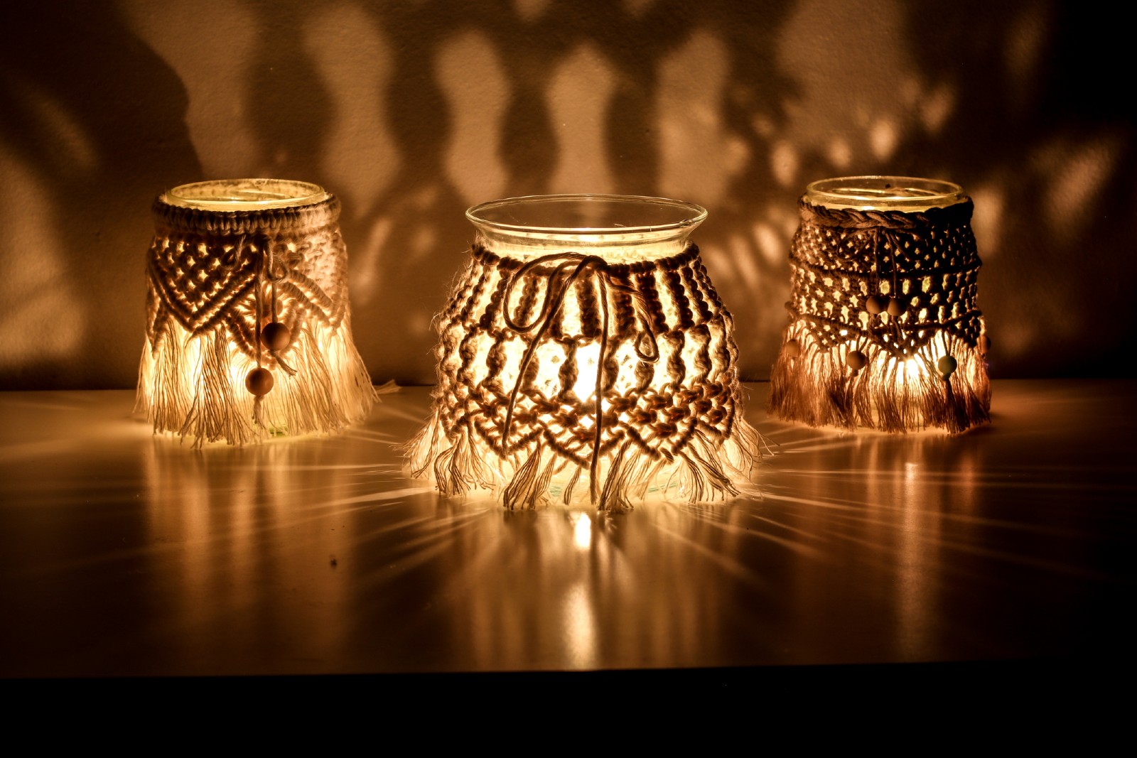 Drei Makramee-Windlichter stehen auf einem Tisch | Credit: iStock.com/janzwolinski