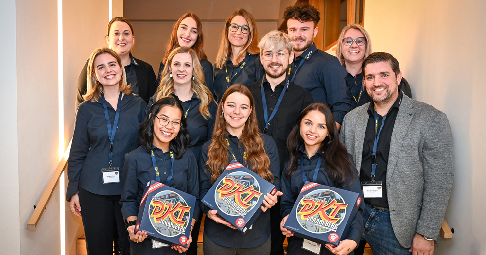 Das Team von APS Personal mit dem Wirtschaftsspiel: (vorne) Joan-Mae Armenio, Jennifer Zadra, Julia Degold, (mitte) Marina Plesa, Melanie Berthold, Patrick Pfister und Martin Hagen (Geschäftsführer) und (hinten) Isabel Fridrich, Iris König, Petra Rasser-Spiegel, Marco Moosmann und Sonja Graf