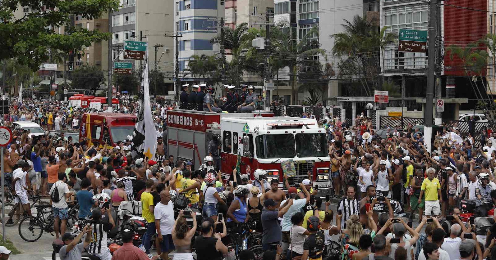Ein Feuerwehrauto mit Pelés Sarg auf dem Dach schiebt sich durch Menschenmassen auf den Straßen der Stadt Santos. | Credit:  CAIO GUATELLI / AFP / picturedesk.com
