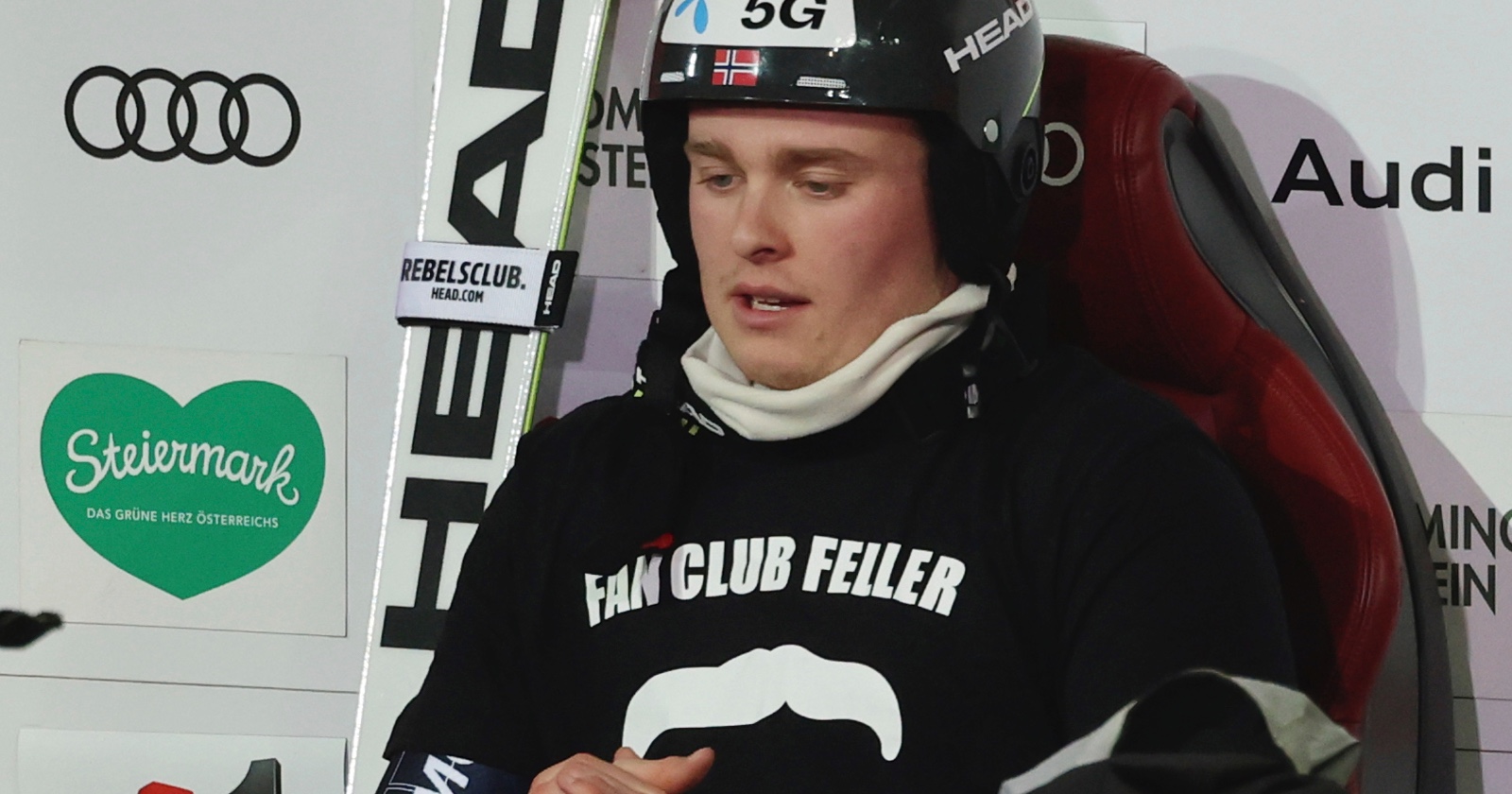 Der norwegische Skifahrer Atle Lie McGrath in einem schwarzen T-Shirt mit der Aufschrift &quot;Fan Club Feller&quot; auf dem Stuhl des Führenden in Schladming
