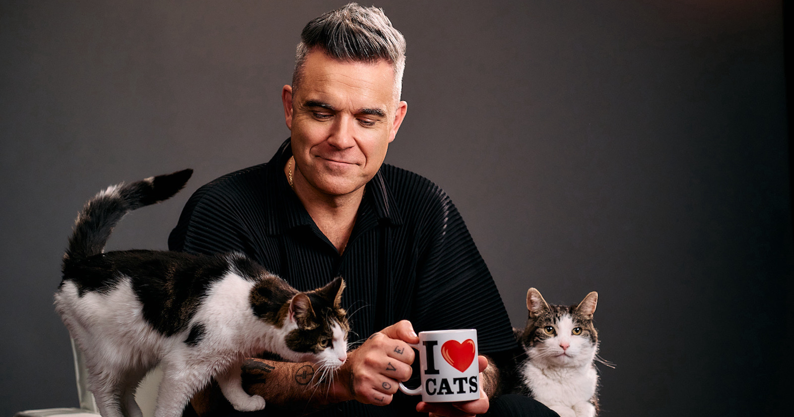 Robbie Williams mit zwei Katzen. | Credit: Linda Hastrich/Nestlé Purina