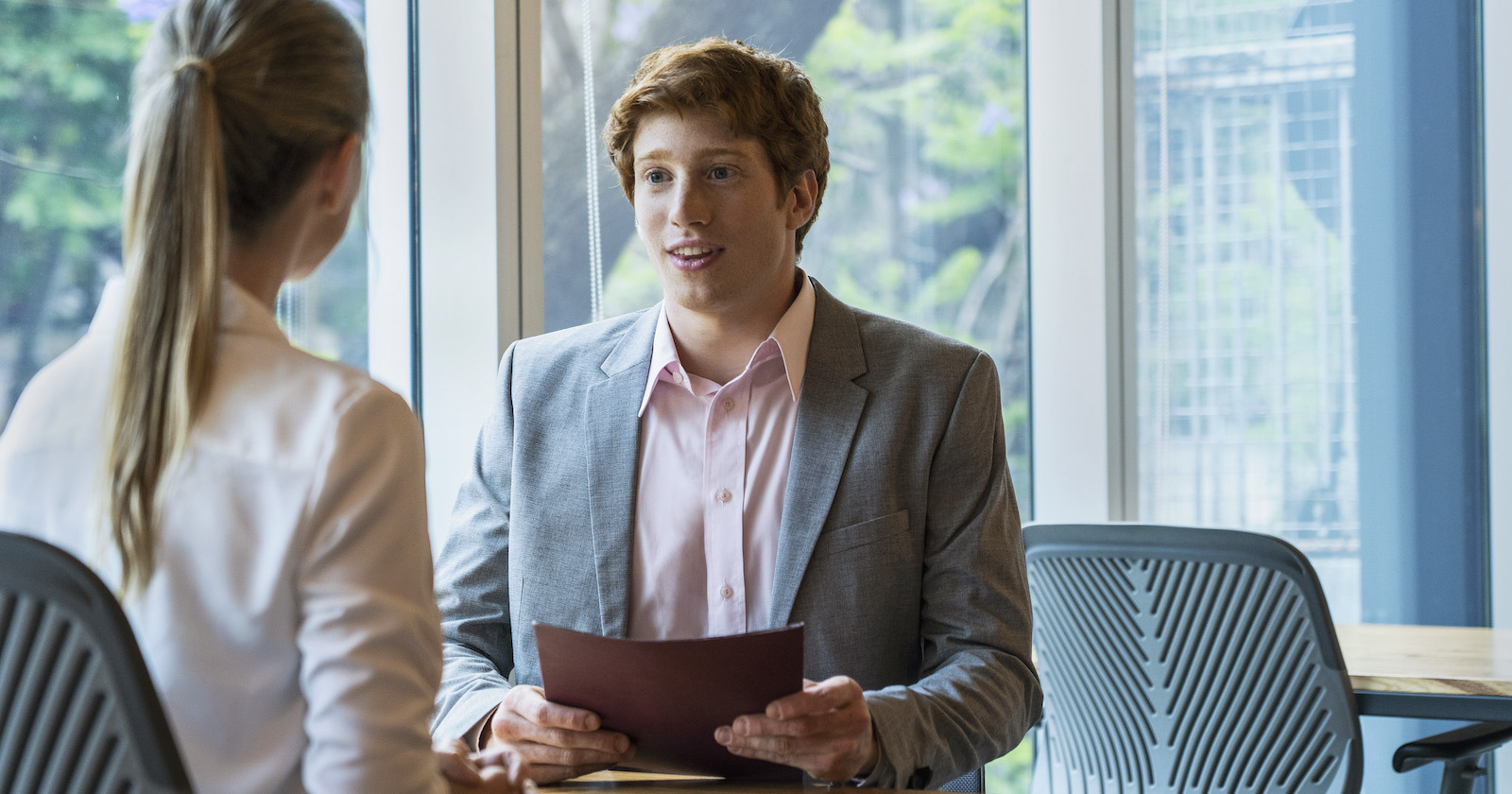 Portät junger Mann in Gespräch mit Frau am Schreibtisch