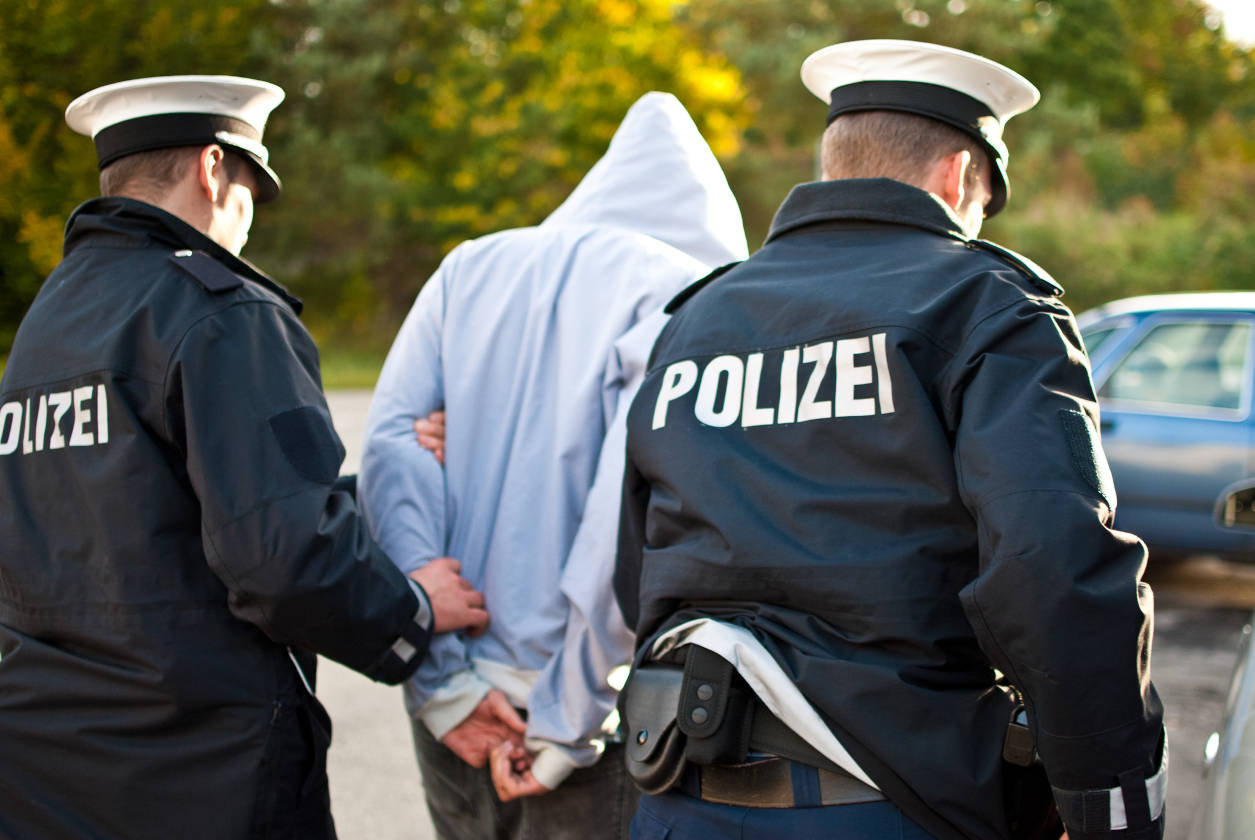 Mann wird von zwei Polizisten festgenommen