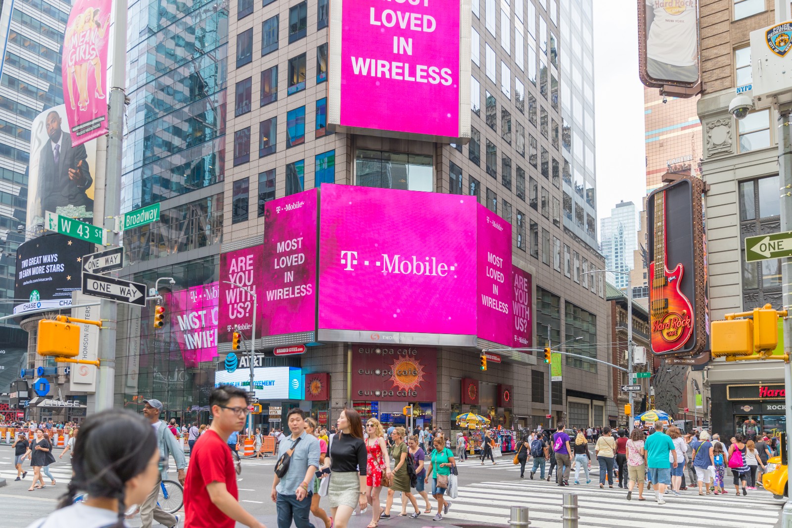 T-Mobile Logo hängt über einer Menschenmenge | Credit: iStock.com/helen89