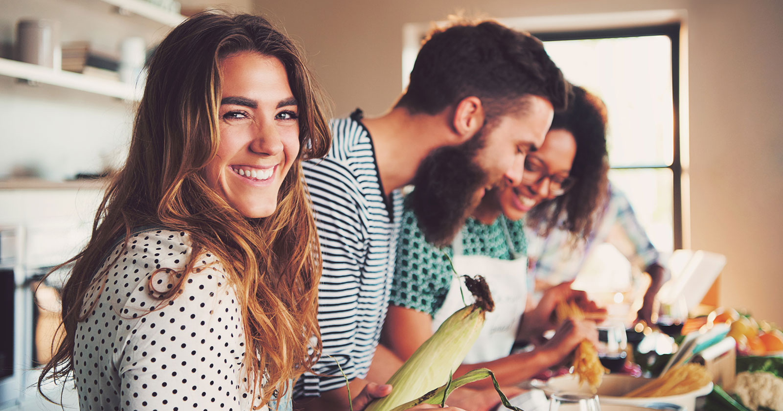 Junge Frauen und Männer beim gemeinsamen Kochen | Credit: iStock.com/FlamingoImages