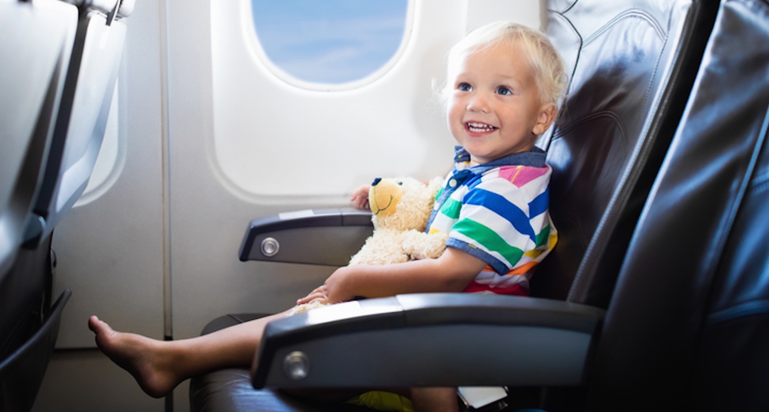 Kleinkind sitzt im Flugzeug und lacht