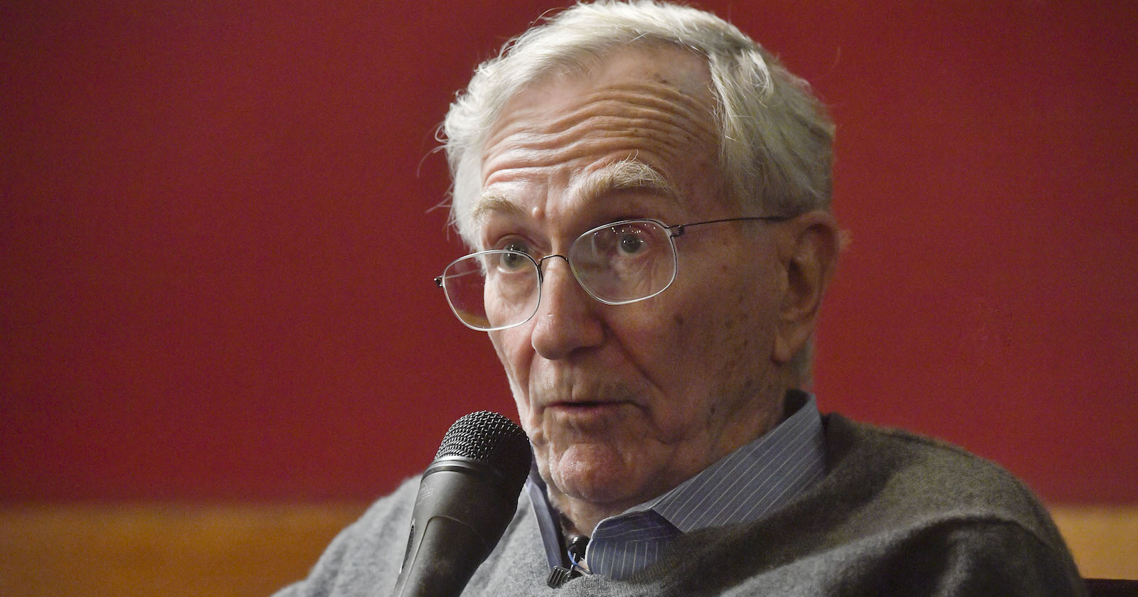 Porträt sitzend mit Mikro in der Hand