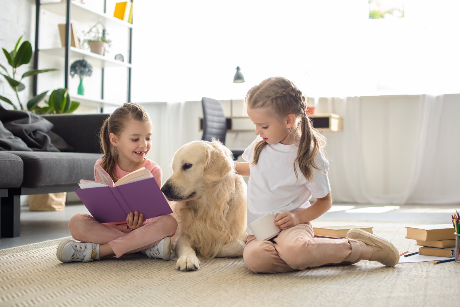 Zwei Kinder lesen ihrem Hund vor | Credit: iStock.com/LightFieldStudios