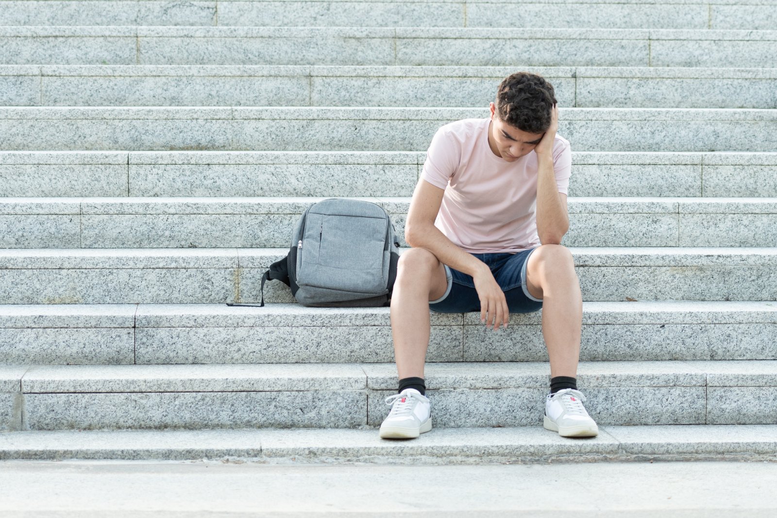 Schüler sitzt frustriert auf einer Stiege | Credit: iStock.com/Egoitz Bengoetxea Iguaran